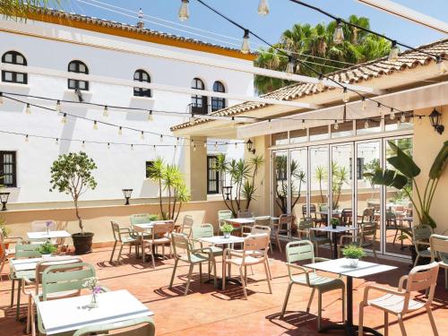 an outdoor patio of a restaurant with tables and chairs at Ibis Sevilla in Seville