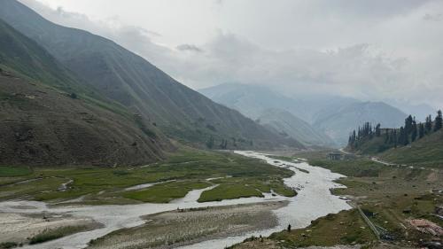 a river flowing through a valley in a mountain at Serene Resorts Naran in Nārān