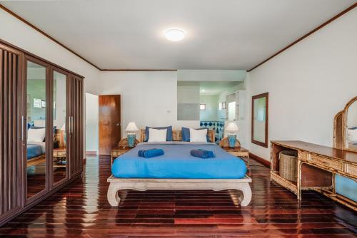 a bedroom with a large blue bed in a room at Tranquility Haven Villa, Kata Beach in Kata Beach