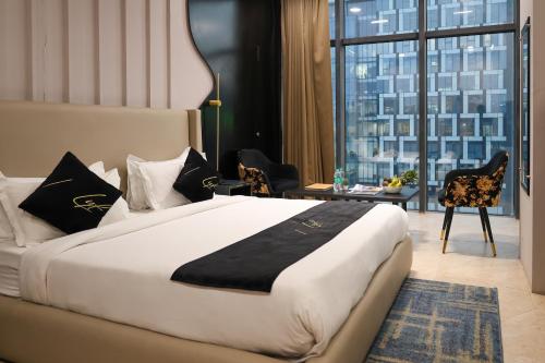 a bedroom with a large bed and a desk with chairs at Aquila Grand Suites - Noida Sector 136 in Noida