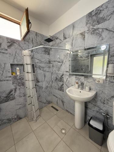 a bathroom with a sink and a shower at Guest House Kloen in Vlorë