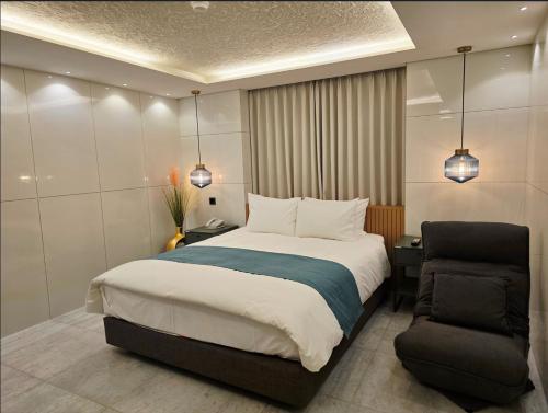 a bedroom with a large bed and a chair at Blueduck hotel in Seoul