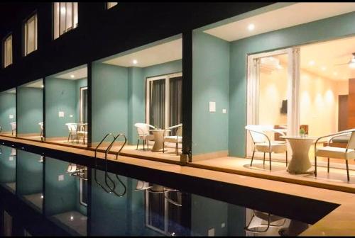 a swimming pool with chairs and tables in a building at Rococo mandrem beach resort in Old Goa