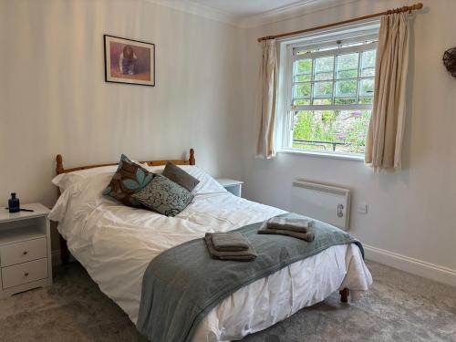 a bedroom with a bed and a window at La Mouette in Mevagissey