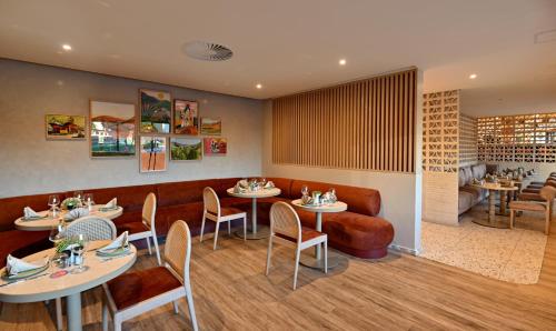 Un restaurante con mesas y sillas y un sofá. en City Lodge Hotel V&A Waterfront, en Ciudad del Cabo