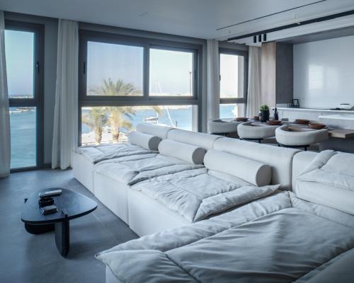 a large white couch in a room with large windows at BirdNest Vacation homes at Marassi marina in El Alamein
