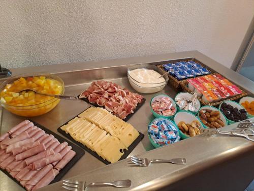 a table with many different types of food on it at Hotel Le Saint Aubin in Gournay-en-Bray