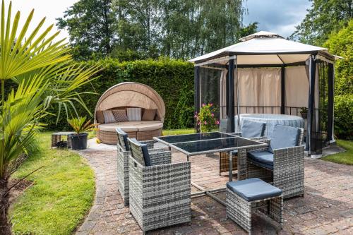 a patio with a table and chairs and a gazebo at Exklusive Traumvilla mit Sauna in Hamburg