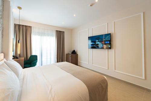 a bedroom with a bed and a tv on a wall at Philia Center Suites in Rhodes Town