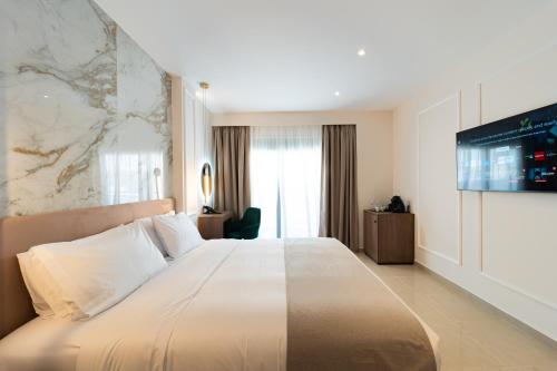 a hotel room with a large bed and a tv at Philia Center Suites in Rhodes Town