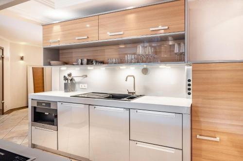 a kitchen with white cabinets and a sink at Exklusive Traumvilla mit Sauna in Hamburg