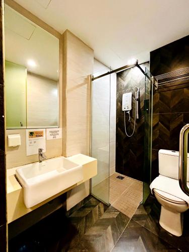 a bathroom with a sink and a shower and a toilet at Kino Hotel in Shah Alam