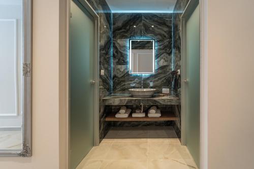 a bathroom with a sink and a mirror at Philia Center Suites in Rhodes Town