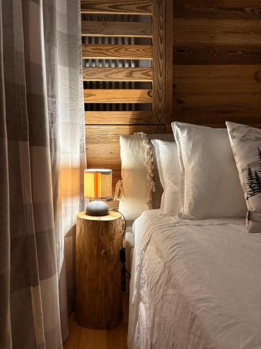 Un dormitorio con una cama y una mesa con una lámpara. en L'Atelier du Temps - Maison du Glacier, en Entrèves