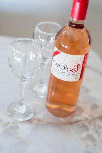 a bottle of wine and two glasses on a table at Spiros house in Svoronata