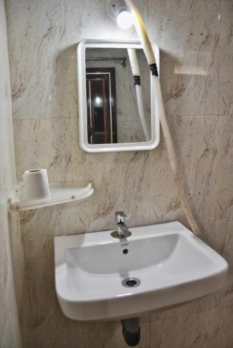 a bathroom with a sink and a mirror at Kartik Resort in Mandrem