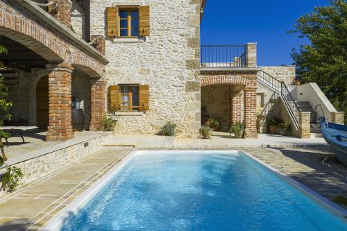 a swimming pool in front of a house at Villa Romantika Dalmacija in Nin