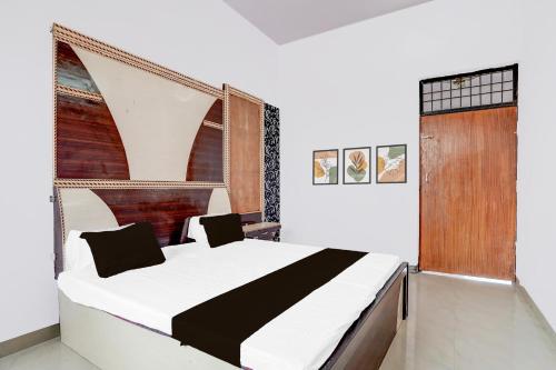 a bedroom with a large bed with a wooden headboard at Hotel O Lord Krishna in Alīgarh