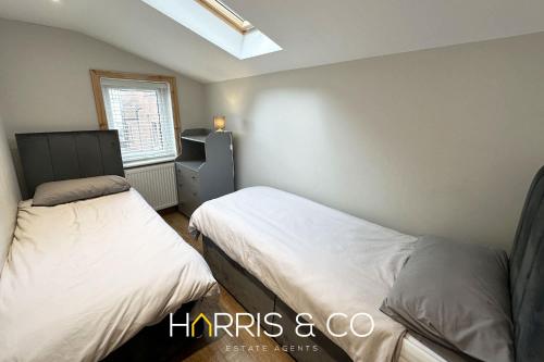 a bedroom with two beds and a window at Admirals Rest in Fleetwood