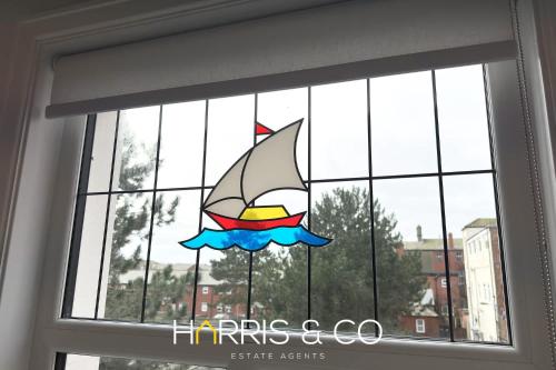 a stained glass window with a sailboat on it at Admirals Rest in Fleetwood