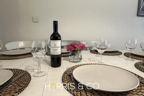 a bottle of wine sitting on a table with glasses at Admirals Rest in Fleetwood