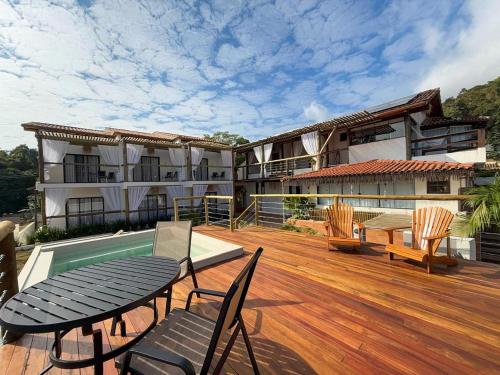 a patio with a table and chairs and a tennis court at Santomar Guest House in Ilhabela