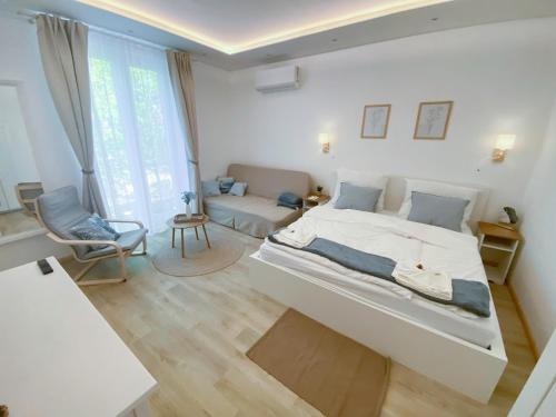 a bedroom with a large bed and a chair at Arany Toboz Vendégház in Siófok
