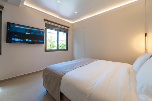 a bedroom with a bed and a tv on the wall at Philia Center Suites in Rhodes Town