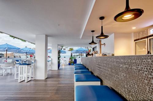 a bar with blue benches and tables and umbrellas at Eurostars Puerto de Ibiza in Ibiza Town