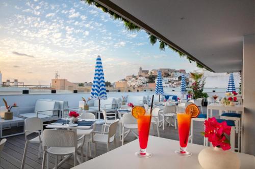 a balcony with tables and chairs on a roof at Eurostars Puerto de Ibiza in Ibiza Town