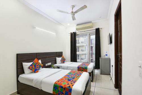 a bedroom with two beds and a window at Gazelle Inn in Gurgaon