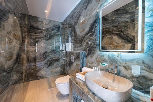 a bathroom with a sink and a toilet at Philia Center Suites in Rhodes Town