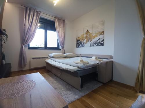 a small bedroom with a bed and a window at Apartman Lux Relax nalazi se u Titovoj vili in Palisad