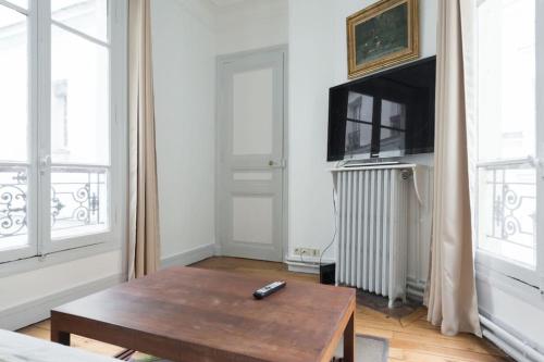 - un salon avec une table basse et une télévision dans l'établissement Bright apartment of 41m2 in the 10th -Paris, à Paris