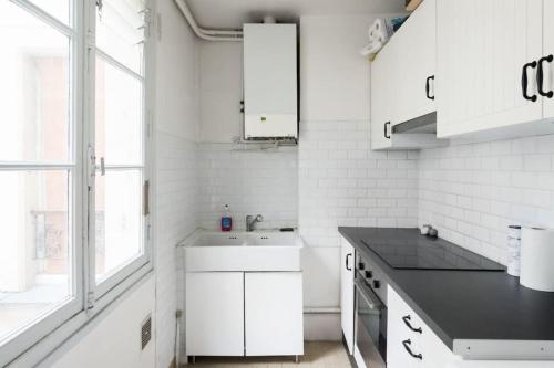 une cuisine blanche avec un évier et un comptoir dans l'établissement Bright apartment of 41m2 in the 10th -Paris, à Paris