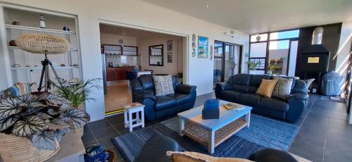 a living room with couches and a table at Tweede Wind in Yzerfontein