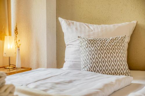 a white bed with a pillow and a lamp at Backbord in der Warener Altstadt in Waren