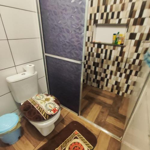 a small bathroom with a toilet and a shower at Pousada Canto dos Pássaros in Campo Mourão