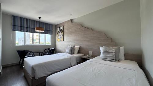 a hotel room with two beds and a window at Methavalai Residence Hotel in Bangkok