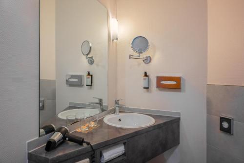 a bathroom with two sinks and a mirror at Hotel Oberhausen Neue Mitte affiliated by Meliá in Oberhausen