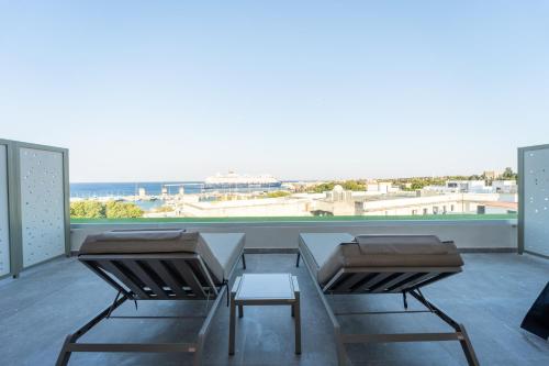 two chairs and a table on a balcony with a view at Philia Center Suites in Rhodes Town