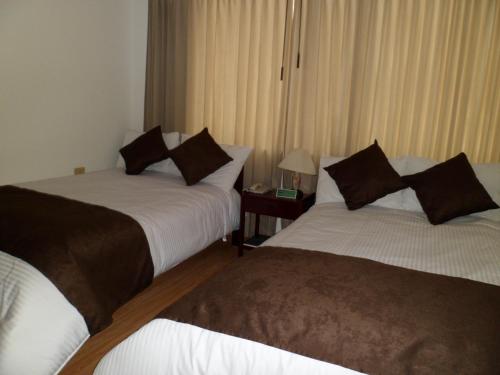 a hotel room with two beds in a room at Hotel Tuvalu in Paipa