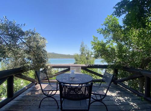 a table and chairs on a deck with a view of the water at Charming 1BR Stone House with Lake View in Bogazici