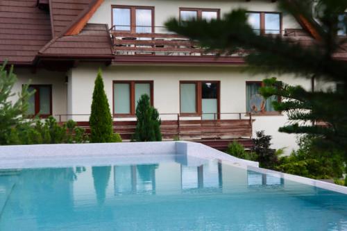 a house with a swimming pool in front of a house at Domki w Białce pod Basenami, 50 m od term i wyciągów in Białka Tatrzanska