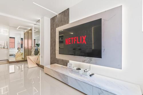 a living room with a television on a wall at Luxury City Apartment, Walk to O2 Academy & Bullring, Sleeps 4 in Birmingham