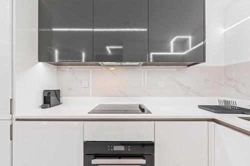 a kitchen with white cabinets and stainless steel appliances at Luxury City Apartment, Walk to O2 Academy & Bullring, Sleeps 4 in Birmingham
