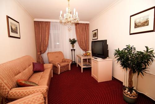 a living room with a couch and a tv at Interhotel Central in Karlovy Vary