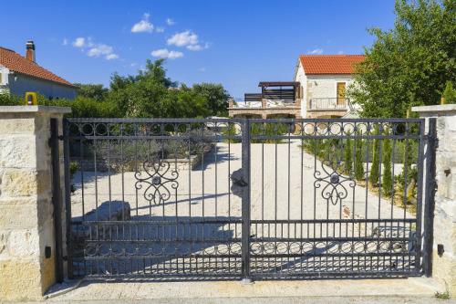 a gate to a driveway with a house in the background at Villa Romantika Dalmacija in Nin