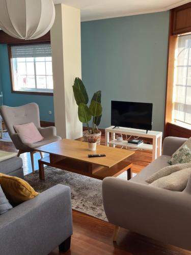 a living room with a coffee table and a tv at Estrela de mar in O Grove