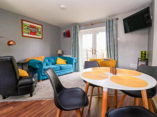 a living room with a table and chairs at 8 Wharfedale Mews in Otley